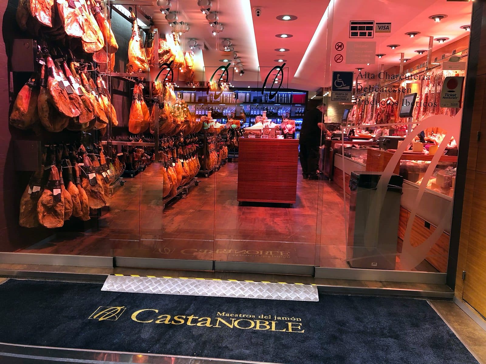 Entrada de la tienda Castanoble en Sant Andreu, Barcelona, con los jamones colgados